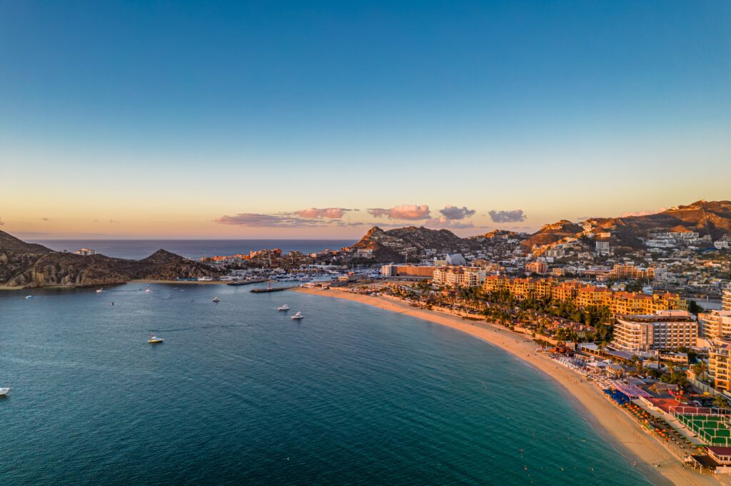 Aerial view of Cabo San Lucas marina with charter boats waterfront resorts.