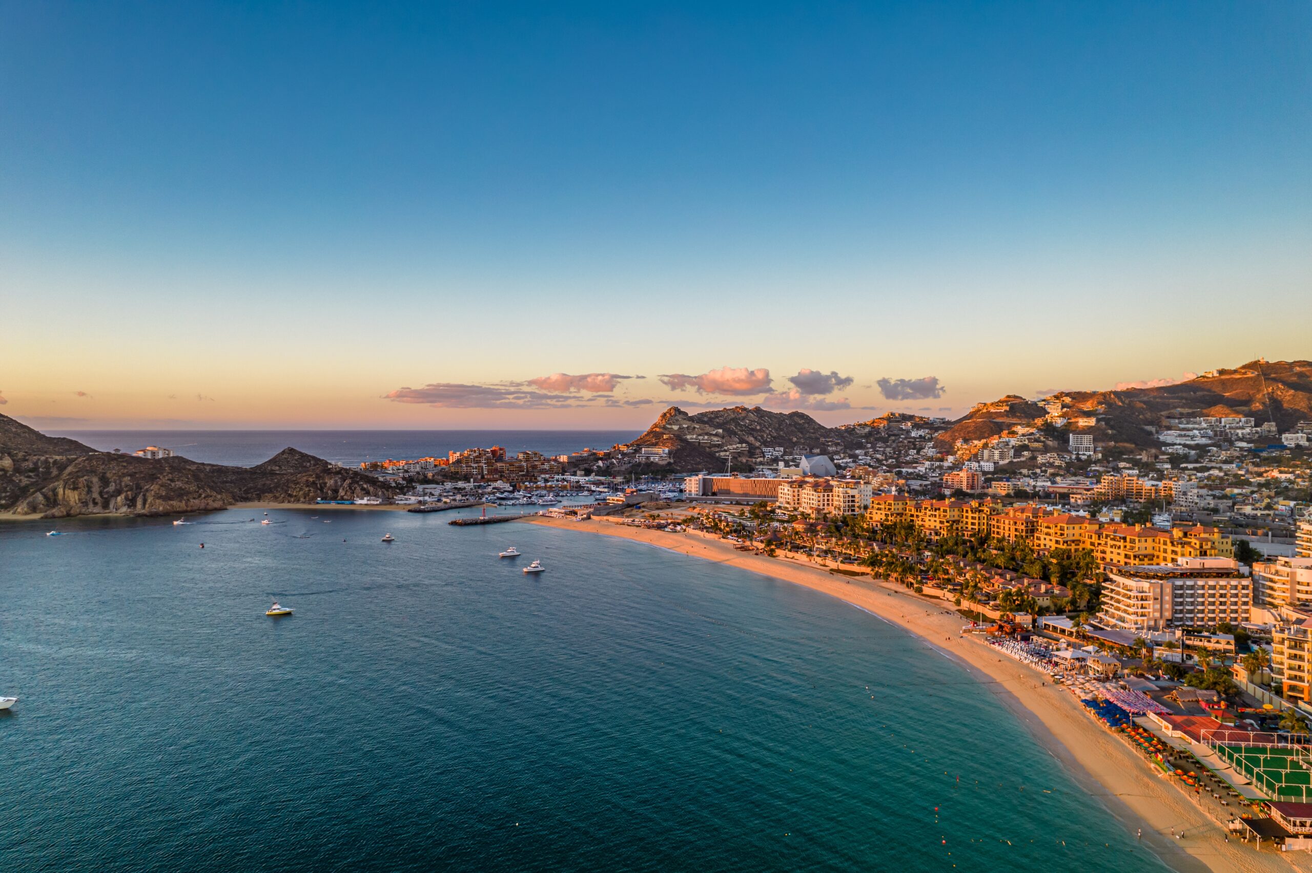 Aerial view of Cabo San Lucas marina with charter boats waterfront resorts.
